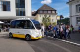 Besucher des SIG-Eröffnungsfests stehen an der Haltestelle ‚Industrieplatz‘ Schlange, um eine Fahrt mit Trapizio zu machen.