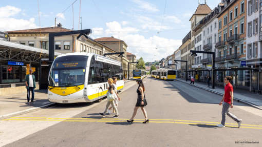Eine Elektrobus der vbsh wartet am Bahnhof Schaffhausen, daneben steht eine blinde Person mit Blindenstock.